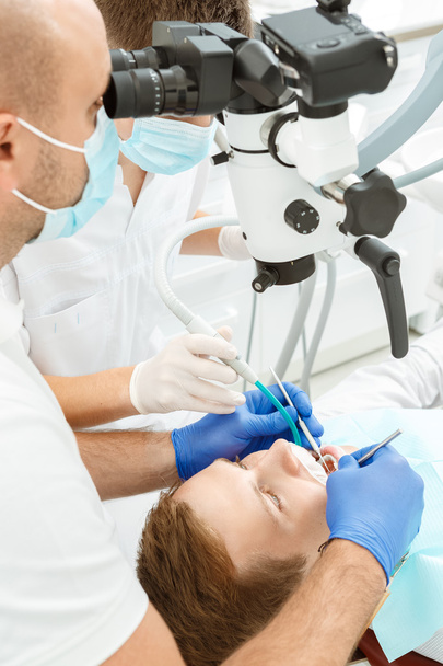 Dentist using dental microscope during inspection - Foto, imagen