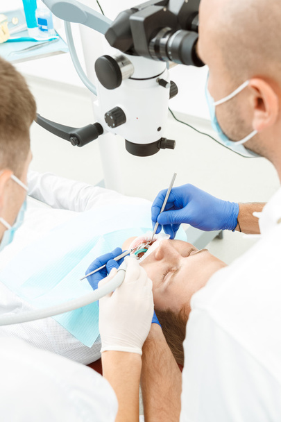 Dentist using dental microscope during inspection - Foto, imagen