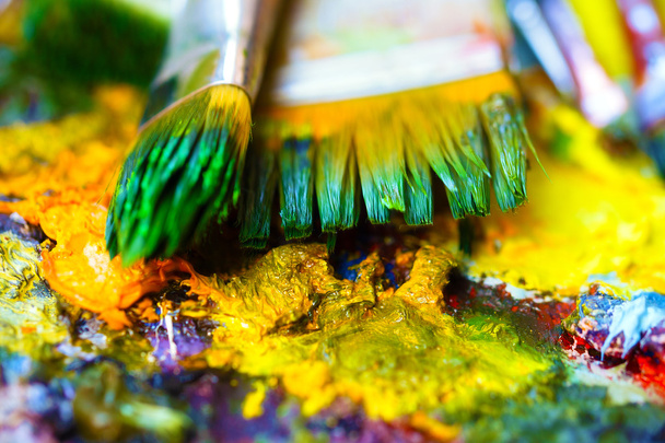 Paint brushes to the painting palette with colors - Photo, Image