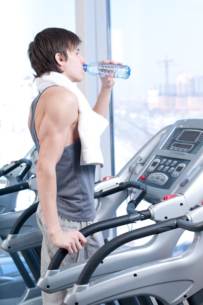 Man at the gym drinking water - Foto, afbeelding