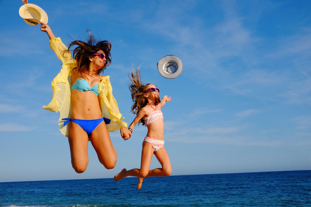 Šťastné holky skáčou dohromady na pláži. - Fotografie, Obrázek