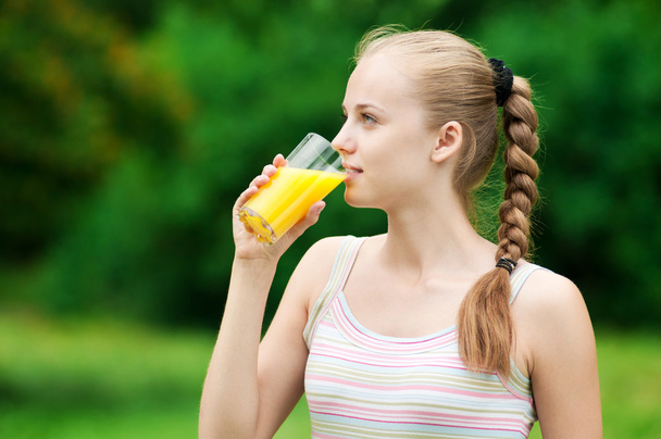 Young woman drinking orange juice. Outdoor - Foto, Imagen