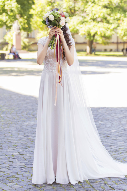 白いウェディング ドレスの準備で保持している彼女の結婚式の花嫁 - 写真・画像