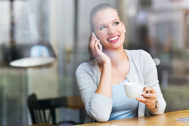 Mujer usando teléfono móvil en la cafetería
 - Foto, Imagen