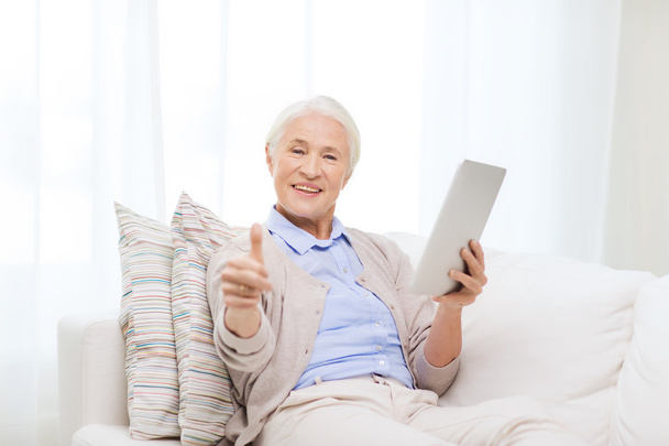 senior woman with tablet pc showing thumbs up - Foto, Imagen