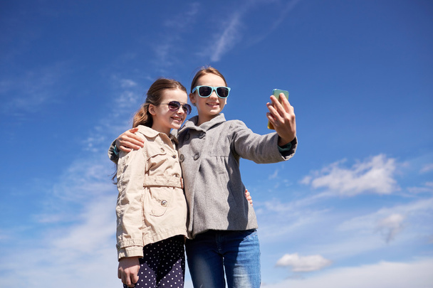happy girls with smartphone taking selfie outdoors - Photo, Image