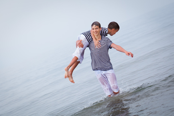 Twee vrolijke, happy, broer speelt op zee - Foto, afbeelding