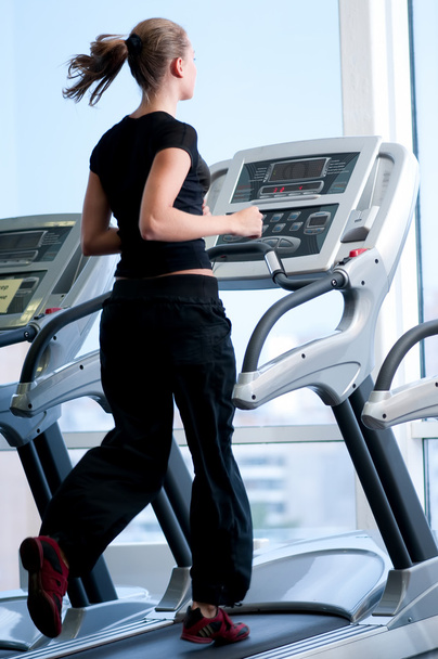 Young woman at the gym. Run on a machine - Foto, Bild