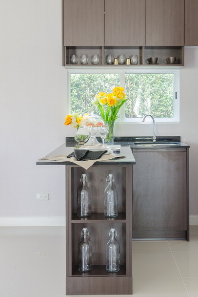 black counter in pantry with vase of plant and modern sink - Fotoğraf, Görsel