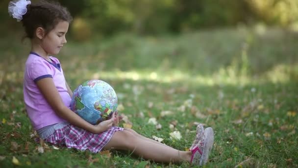 Teen Brünette Mädchen sitzen auf grünem Gras spielen Studium Globus glücklich - Filmmaterial, Video