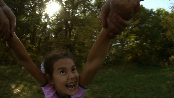 ευτυχισμένος κορίτσι έφηβος κόρη τρέχει προς τον πατέρα της στροβίλισμα με βότσαλα τα χέρια σχετικά με τη φύση του παιχνιδιού - Πλάνα, βίντεο