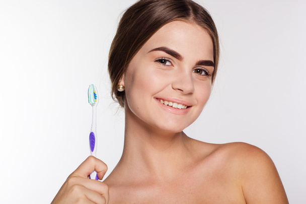Sonriente chica está sosteniendo cepillo con pasta de dientes
 - Foto, Imagen