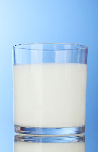 Tasty milk in glass on blue background - Photo, image