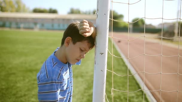 Teen chlapec zvrácena porážku klepání cíl cíl post čisté stadion trávník - Záběry, video