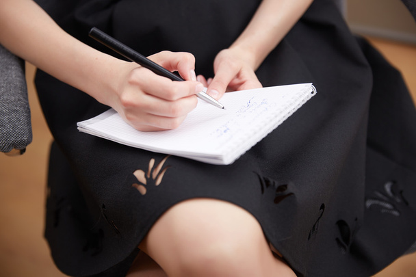 Businesswoman writing in notepad  - 写真・画像