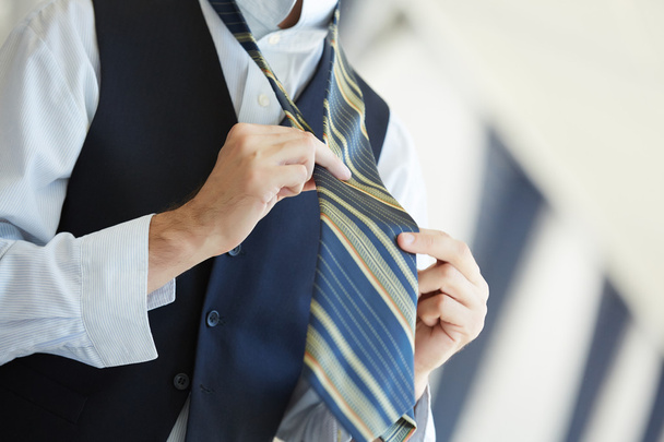 Businessman tying tie - Zdjęcie, obraz