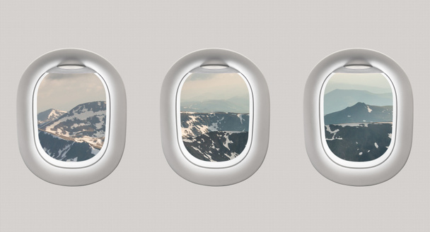 Guardando fuori dai finestrini di un aereo verso le montagne
 - Foto, immagini