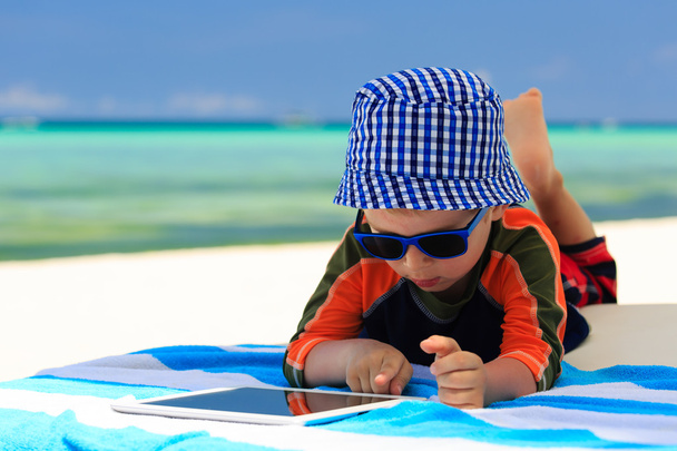 pequeno menino playin no toque pad na praia
 - Foto, Imagem