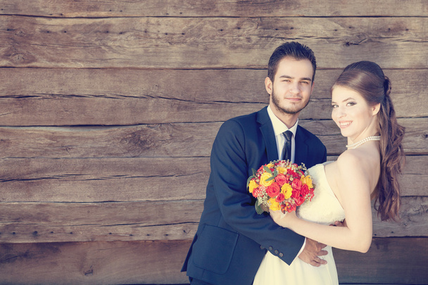 Smiling bride and groom on wooden background - Fotoğraf, Görsel