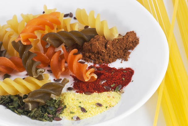 Colored pasta on the plate with spaghetti - Foto, afbeelding