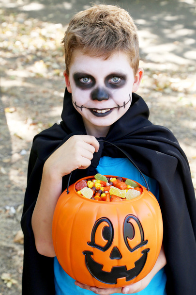 Malý chlapec v halloween kostýmu s košíkem pro bonbóny v p - Fotografie, Obrázek