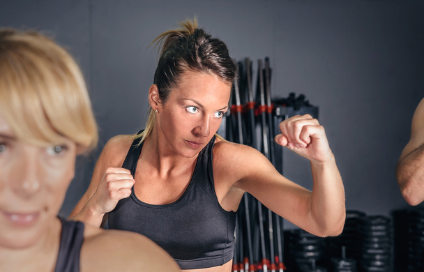 Woman training hard boxing in the gym - Foto, afbeelding