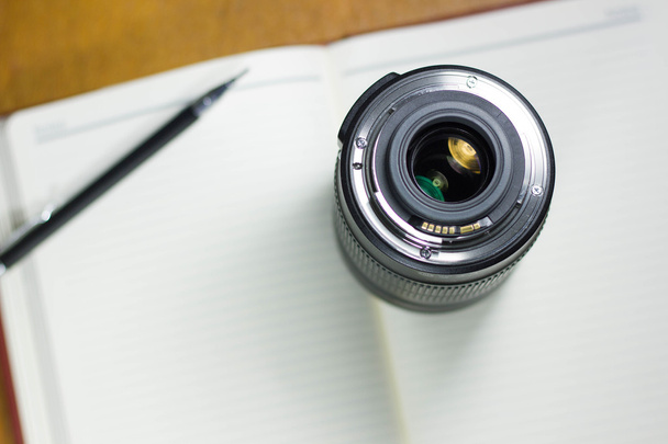 Φακό της κάμερας φωτογραφία στο σημειωματάριο, έννοια φωτογραφίας - Φωτογραφία, εικόνα