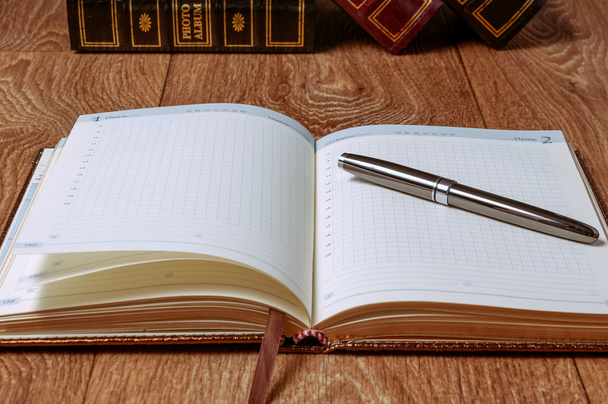 Bloco de notas e caneta na mesa de madeira
 - Foto, Imagem