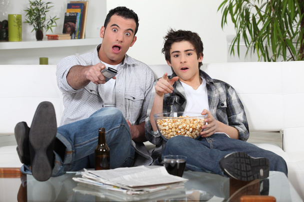 Father and son watching television together - Photo, image