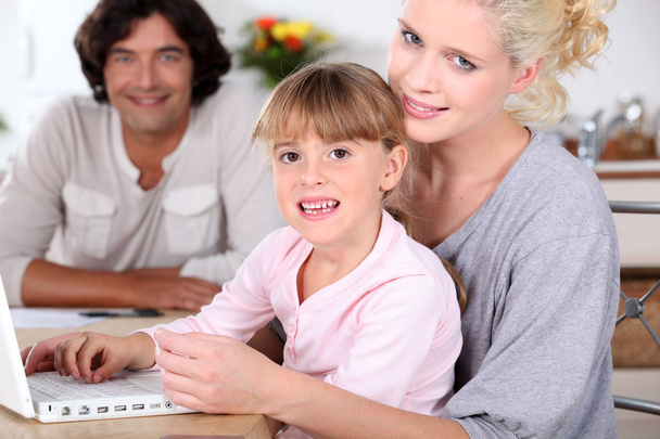 Genitori e figlia che utilizzano un computer portatile
 - Foto, immagini