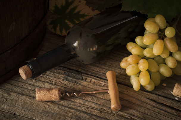 red wine bottle and wodden barrel, vineyard on background - Foto, imagen