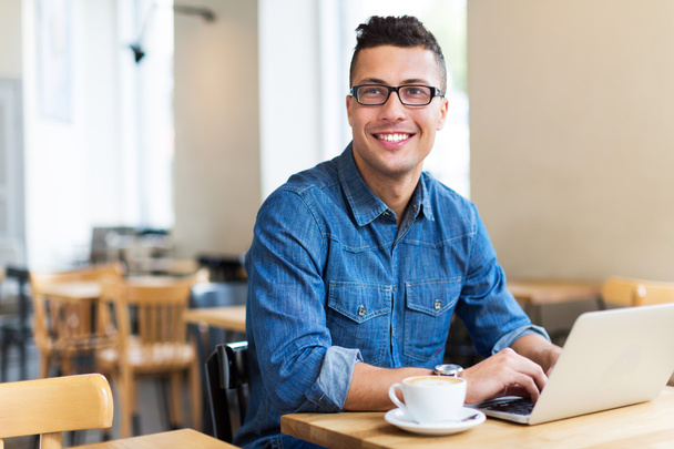 fiatal férfi használ laptop kávézóban - Fotó, kép