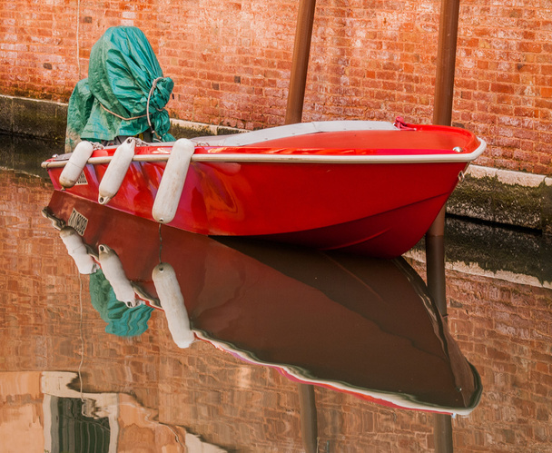 gefesseltes rotes Boot in der Nähe eines Hauses auf der Straße von Venedig - Foto, Bild