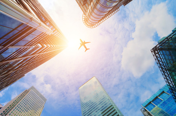Avião sobrevoando arranha-céus de negócios modernos
. - Foto, Imagem