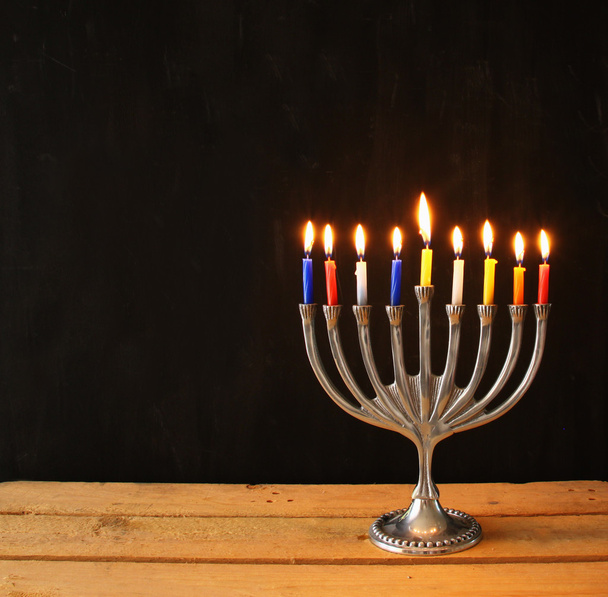 Image of jewish holiday Hanukkah background with menorah (traditional candelabra) Burning candles over black background. - Photo, Image