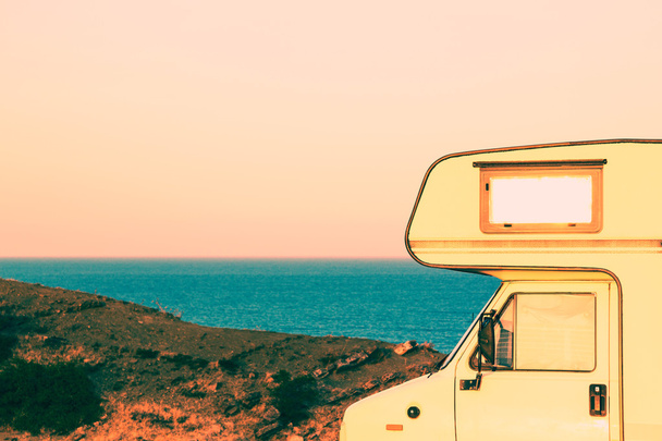 Une partie du camping-car sur le bord de la mer au coucher du soleil
 - Photo, image