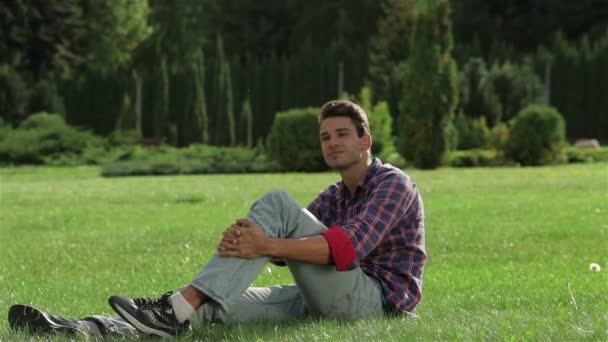 Człowiek cieszący się resztą na trawie - Materiał filmowy, wideo