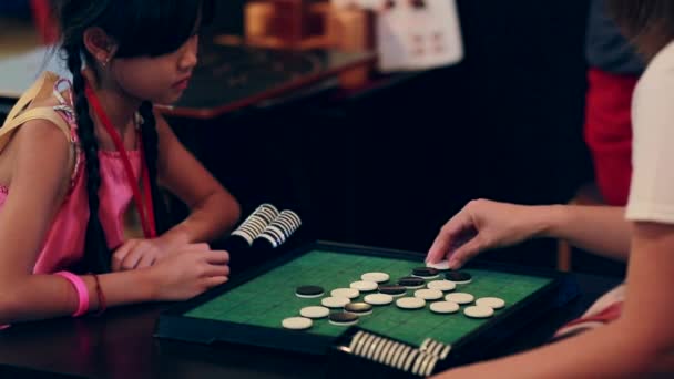 Felice ragazza asiatica gioco da tavolo con amico, sorriso faccia
 - Filmati, video
