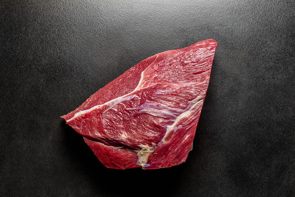 Overhead view fresh raw beef on black deck - 写真・画像