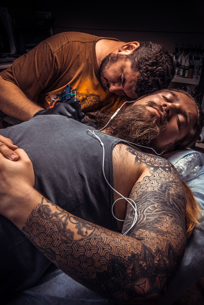 Artista profesional del tatuaje en el trabajo en el salón de tatuajes
 - Foto, Imagen