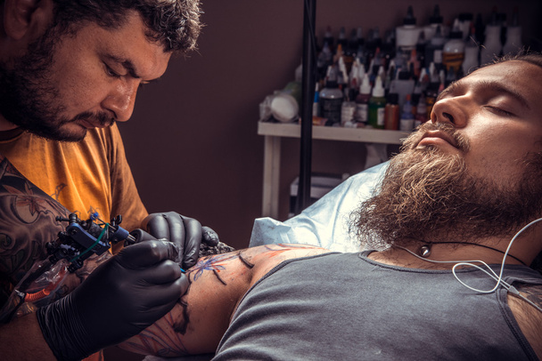 Tattooer dělá tetování v salonu tatoo - Fotografie, Obrázek