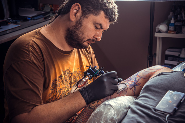 Mężczyzna rękawiczkach Dokonywanie tatuażu Studio tatuażu - Zdjęcie, obraz