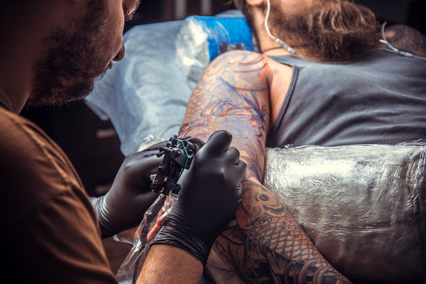 Професійний художник татуювання створює татуювання в студії
 - Фото, зображення