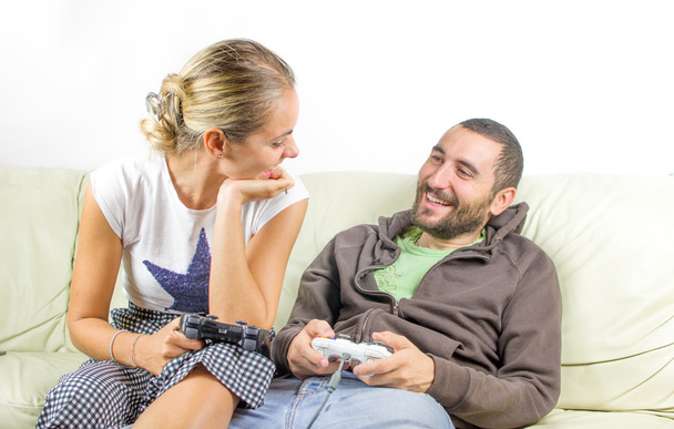 веселая пара смотрит друг на друга, как они играют в видеоигры на co
 - Фото, изображение