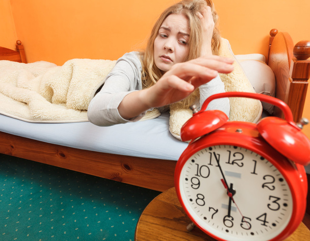 Woman waking up turning off alarm clock in morning - Foto, Bild