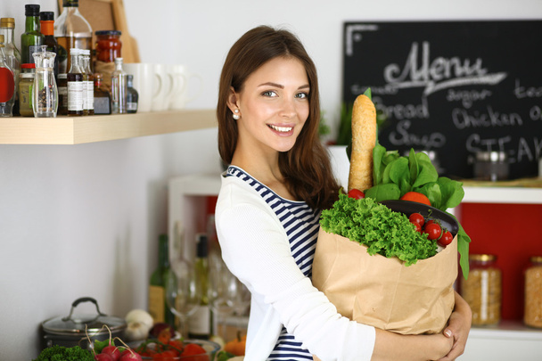 Mujer joven sosteniendo bolsa de la compra de comestibles con verduras - Foto, imagen