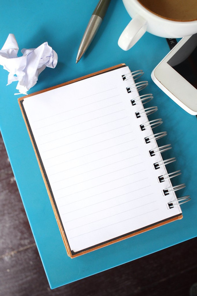 Bloco de notas em branco e smartphone com café na mesa de escritório
 - Foto, Imagem
