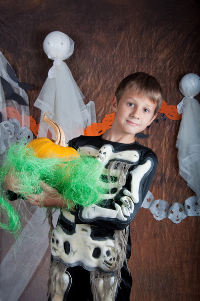 хлопчик в костюмі Хеллоуїна з апельсиновою гарбузом
 - Фото, зображення