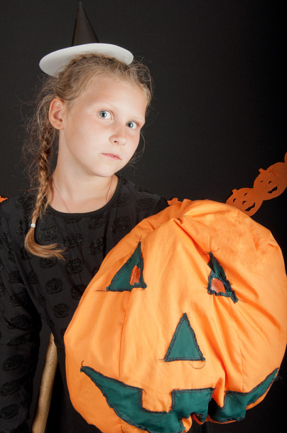 Dívka v halloween kostýmu s dýní na černém pozadí - Fotografie, Obrázek