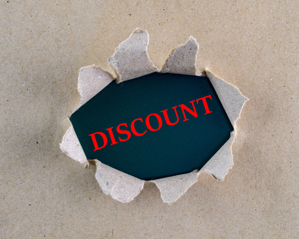 Torn brown rough textured paper with "Discount" word at background surface. - Foto, Imagem